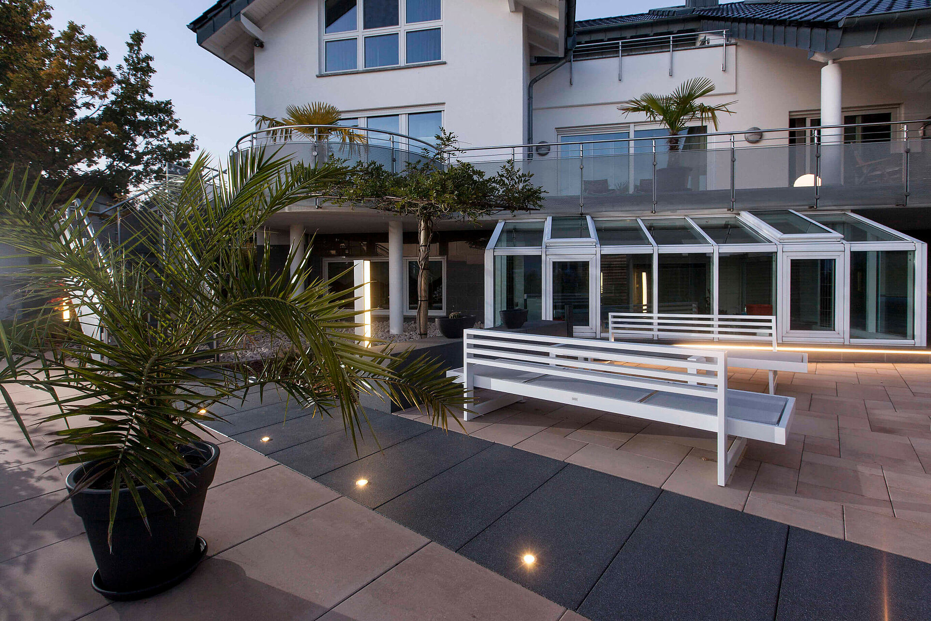 Die LED-Lichter in den dunkelgrauen silkstone® Platten weisen abends den Weg zur Terrasse.